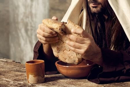 耶穌就吩咐群眾坐在地上，拿起那七個餅來，祝謝了，擘開，遞給他的門徒，叫他們分開